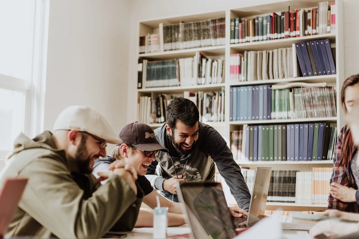 Studenti che studiano insieme davanti a un portatile in biblioteca