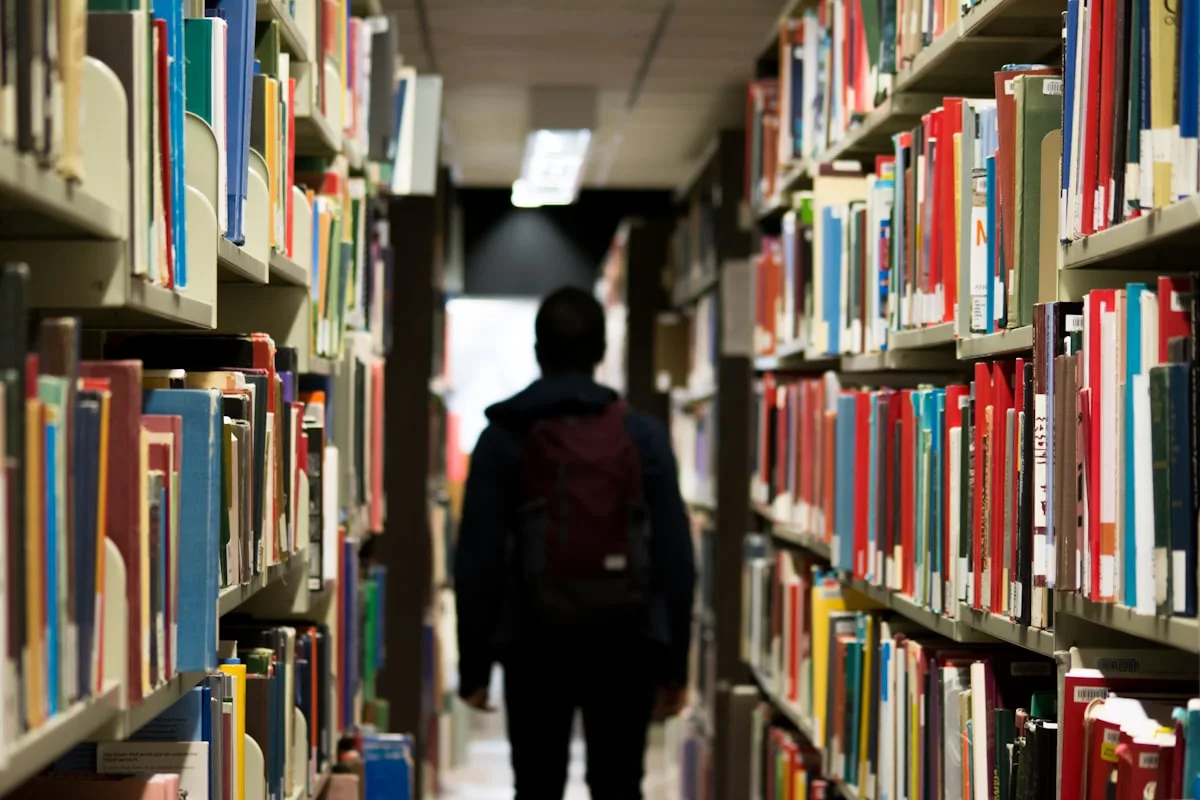 Corridoio di una biblioteca scolastica con scaffali pieni di libri