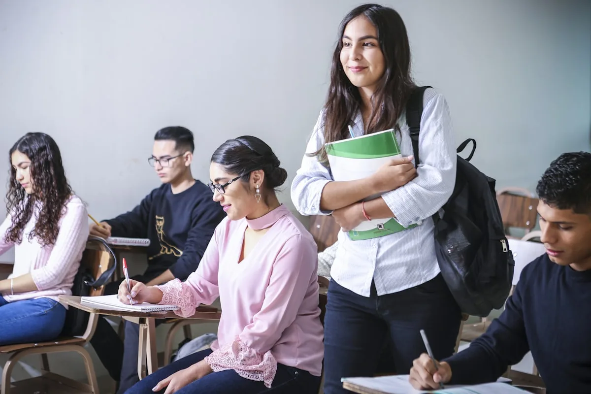 Studenti di scuola superiore seguono la lezione in aula con quaderni e appunti