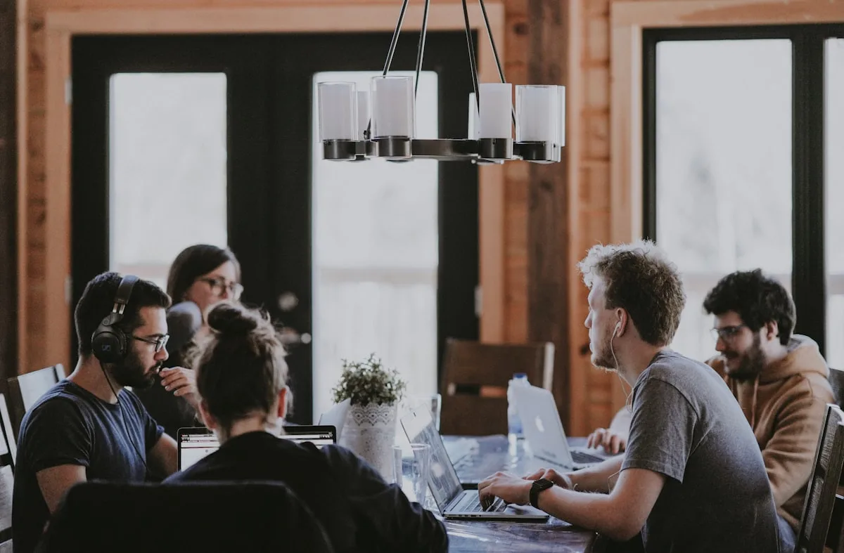 Persone che lavorano insieme al portatile attorno a un tavolo